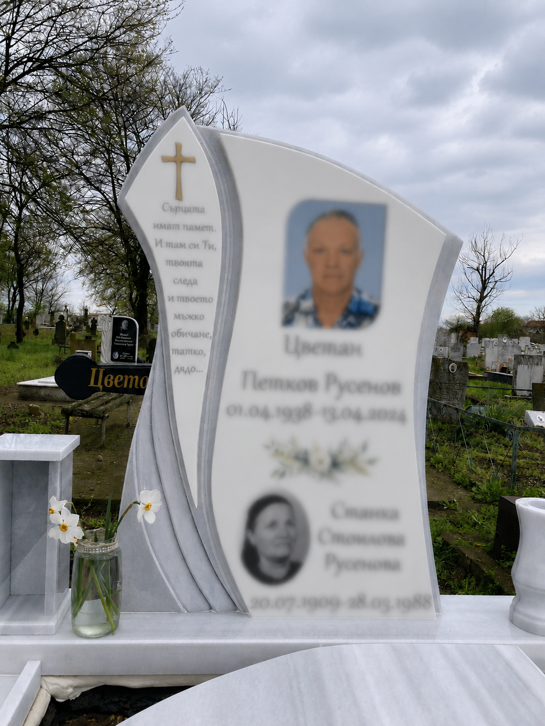 Паметник с бяла плоча с букет и кръст
